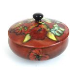A Moorcroft pot decorated in an orchid pattern on a red ground, dia.