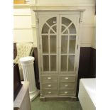 A modern white painted glazed door cabinet having six drawers to base