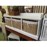 A white laminated storage unit with three wicker baskets