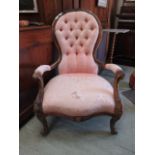 A Victorian walnut nursing chair upholstered in a faded pink button back fabric, the serpentine seat