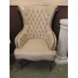A reproduction cream upholstered button back chair