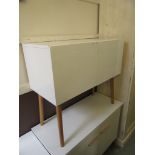 A modern white glossed two door cabinet on turned circular supports