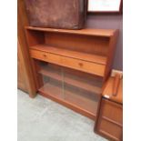 A mid-20th century teak cabinet having glazed sliding doors to base with two doors and open storage