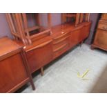 A mid-20th century teak sideboard having three drawers flanked by cupboard doors