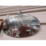 A mid-20th century oval bevel glass wall mirror