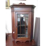 An Edwardian mahogany inlaid corner wall mounted cupboard with glazed door