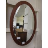 A mid-20th century design teak oval wall mirror