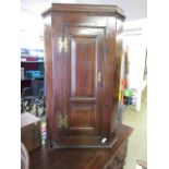 A 19th century oak wall mounted corner cabinet with single door