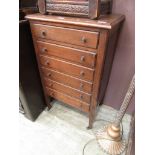 An early 20th century oak six drawer music cupboard