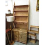 A hand crafted bookcase having open storage above two drawers,