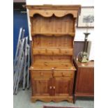 A modern pine dresser having plate rack top top with three drawers,