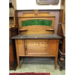 An early 20th century oak wash stand having a grey marble base with a green tiled back