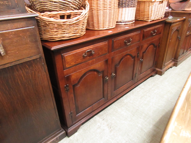A modern high quality oak dresser base having three drawers over three field panel doors
