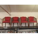 A set of four early 20th century beech framed and caned side armchairs upholstered in a striped red