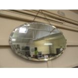 An early 20th century bevel glass oval wall mirror