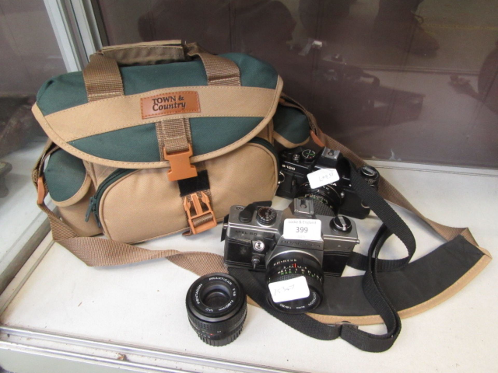 Two cameras and one lens together with a cased JVC video camera