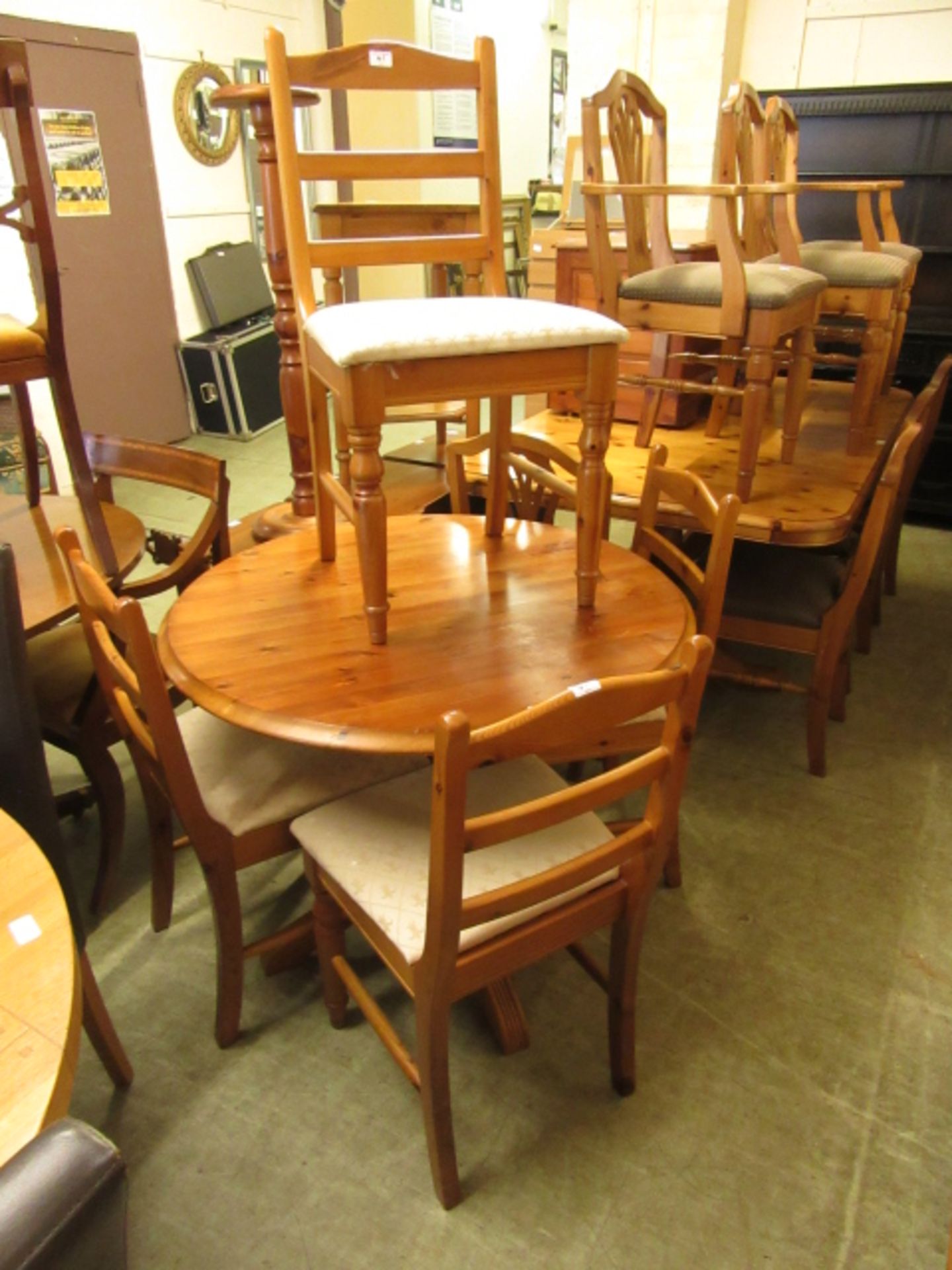 A circular pine kitchen table along with a set of four matching chairs