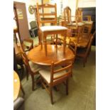 A circular pine kitchen table along with a set of four matching chairs