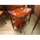 A reproduction mahogany and inlaid trolley the top over end drawer and under tier