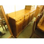 A pine dresser base with four drawers over four cupboard doors