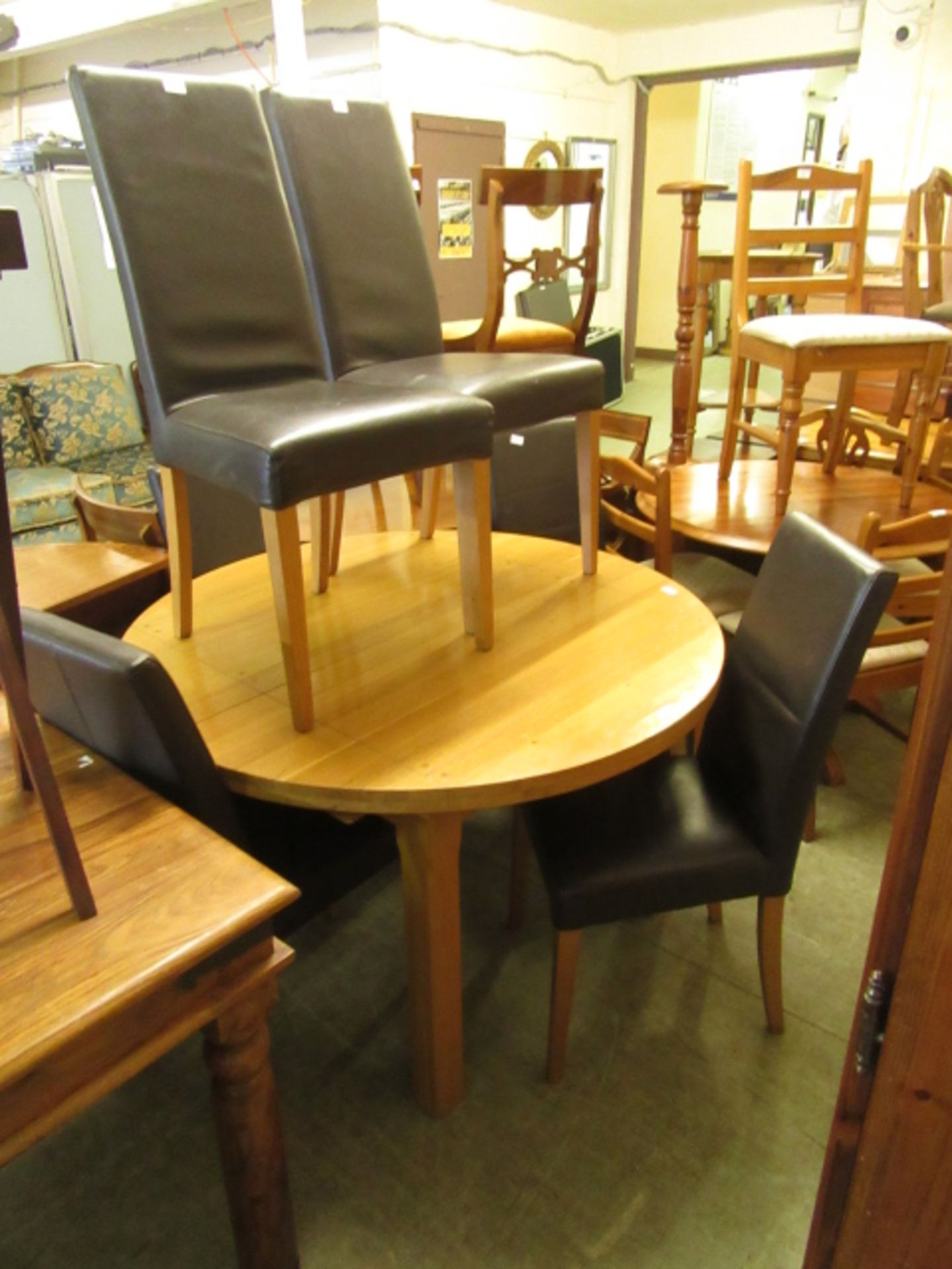 An extending oak dining table along with a set of six leatherette upholstered dining chairs