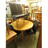 An extending oak dining table along with a set of six leatherette upholstered dining chairs