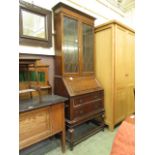 An early 20th century oak bureau bookcase having a pair of glazed doors to top with the base having