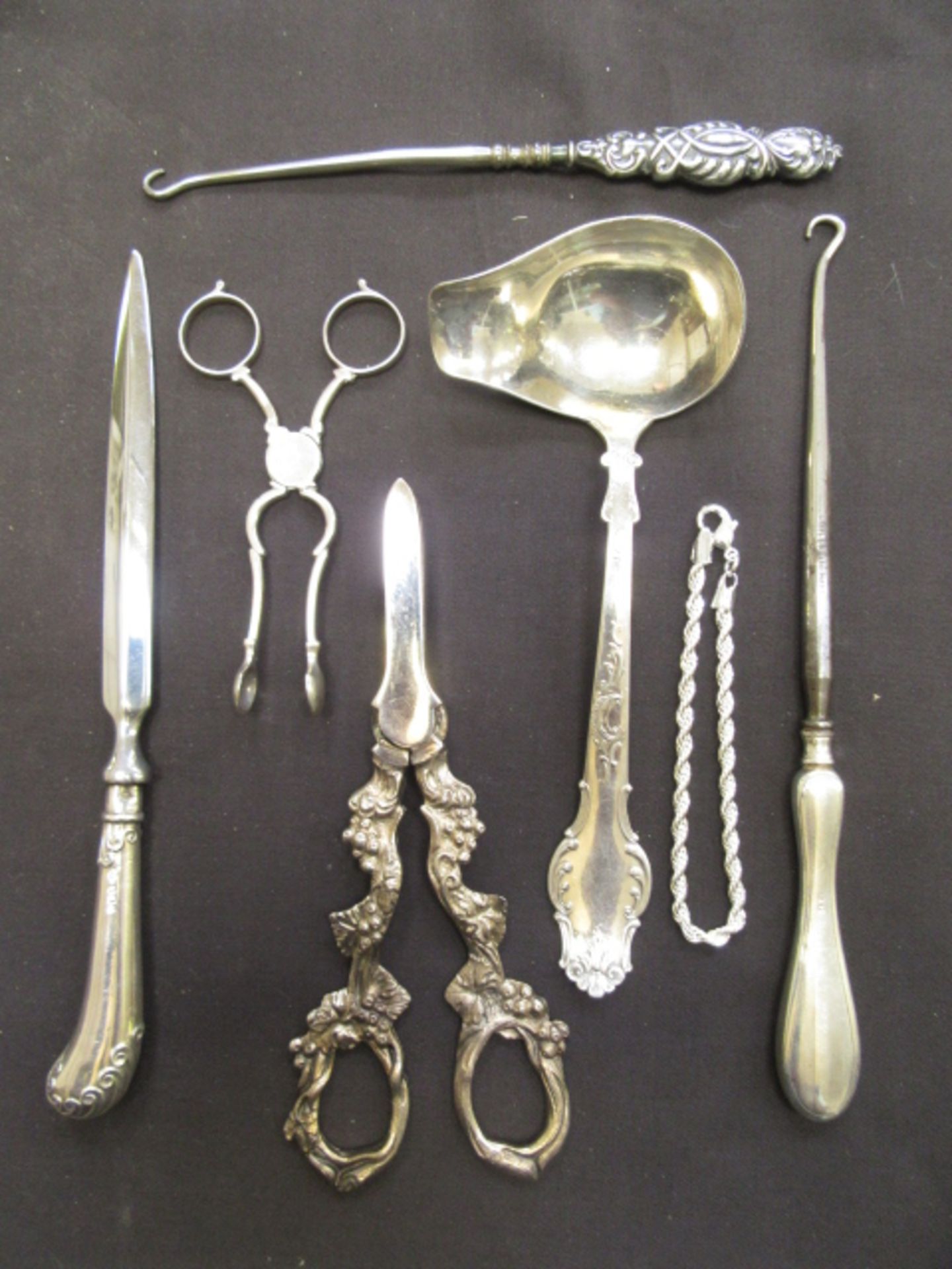 A bag containing a quantity of white metal and silver spoons, letter opener etc.