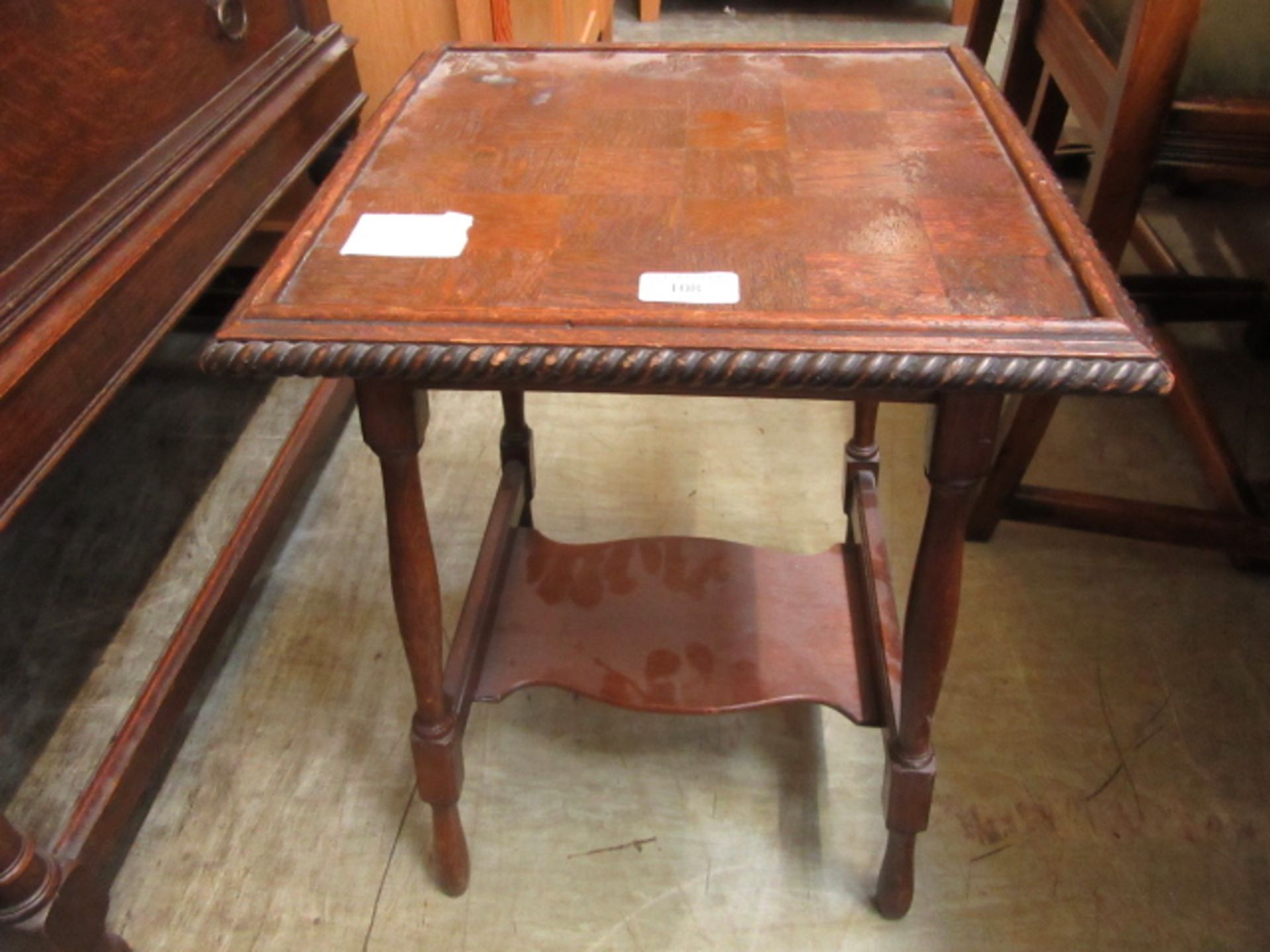 An early 20th century oak occasional table with under tier