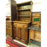 An early 20th Century oak dresser having a plate rack to top,