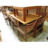 A mid-20th century design teak extending dining table with a set of six matching chairs