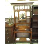 An Edwardian walnut hall stand with coat hooks flanking a bevel glass mirror over a glove box and