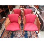 A set of four early twentieth century beech framed and caned side armchairs upholstered in a