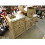 A floral painted chest of three drawers together with a pair of matching bedside cabinets and a
