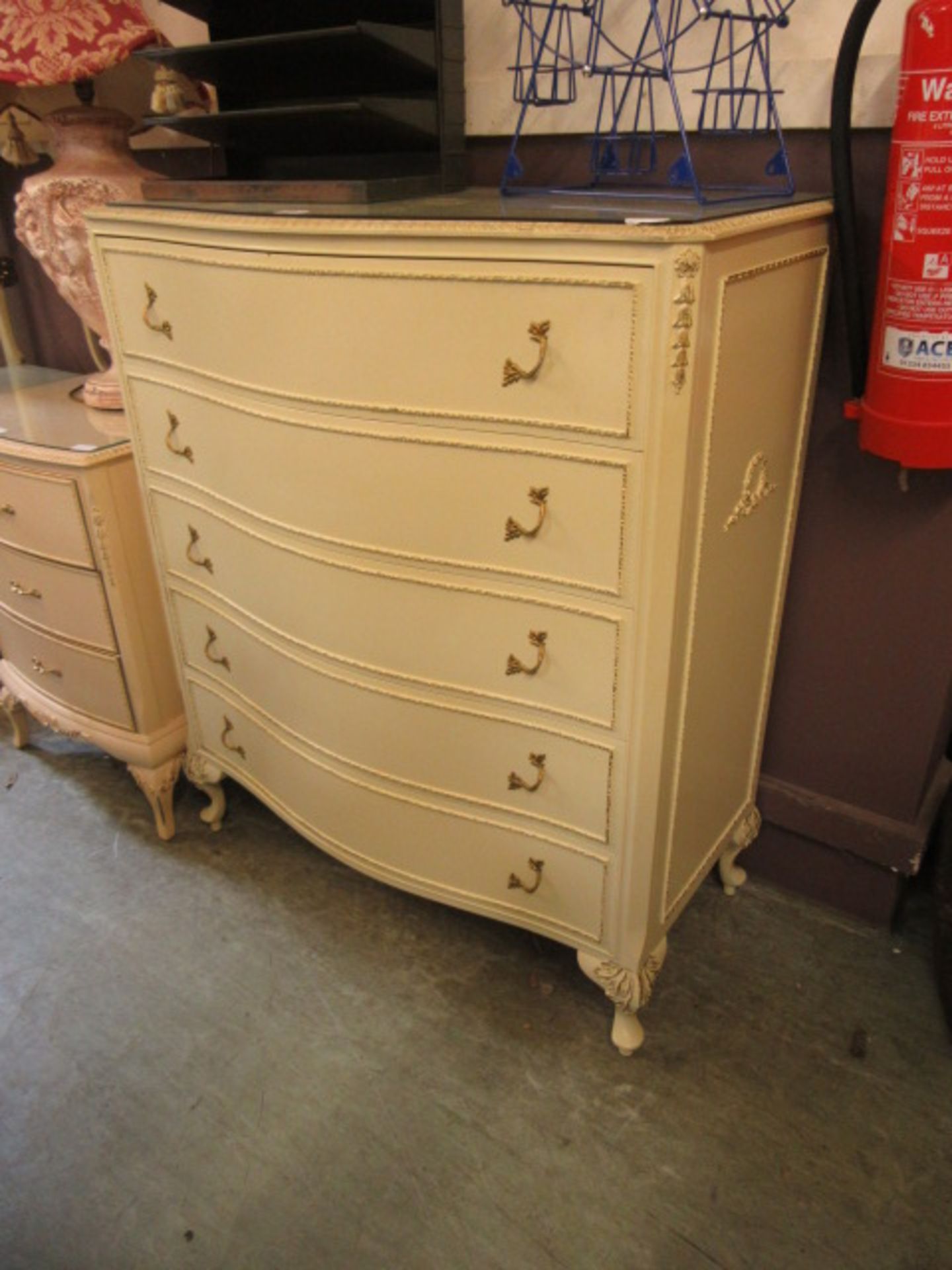 A queen Anne style serpentine fronted cream and gold painted five drawer chest