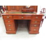 An early twentieth century walnut twin pedestal desk with a tooled green leather insert in the top