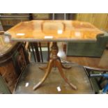 A reproduction flame mahogany pedestal occasional table