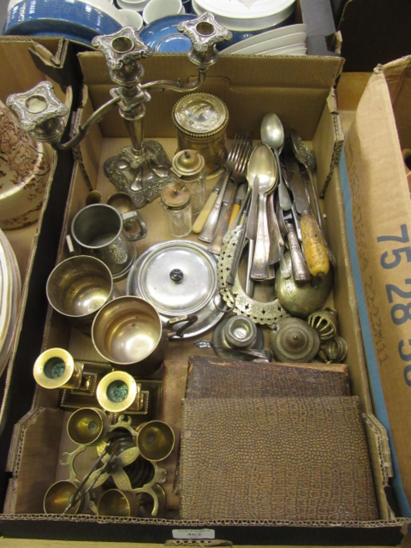 A tray containing assorted flatware, brass candle sticks, candelabra etc.
