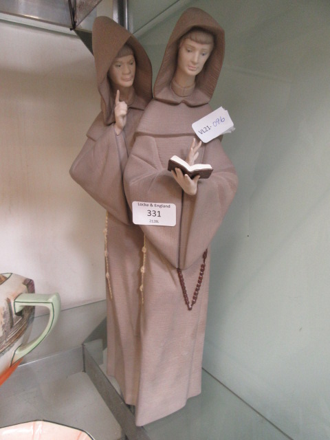 An unglazed Lladro model of two monks