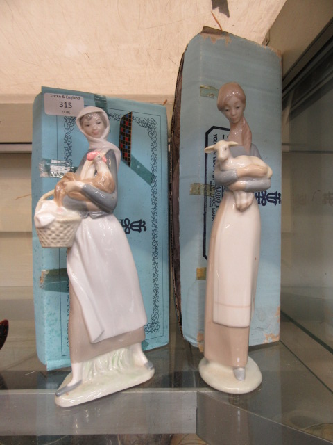 Two boxed Lladro figurines, one of young girl carrying a lamb,