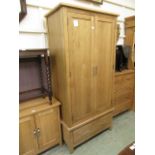 A modern oak two door wardrobe with a drawer at the base