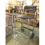 A pair of grey metal framed chairs with a black PVC string seat and back