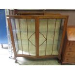 An early 20th century oak serpentine front display cabinet