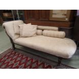 An Edwardian walnut chaise longue upholstered in a floral pattern,