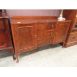 An early 20th century walnut sideboard three central drawers flanked by cupboard doors