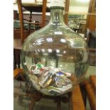 A glass carboy containing a collection of matchboxes