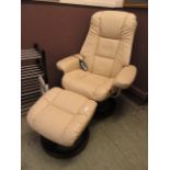 A modern cream leather upholstered massage chair with footstool