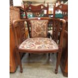 An Edwardian upholstered walnut and inlaid bow back armchair