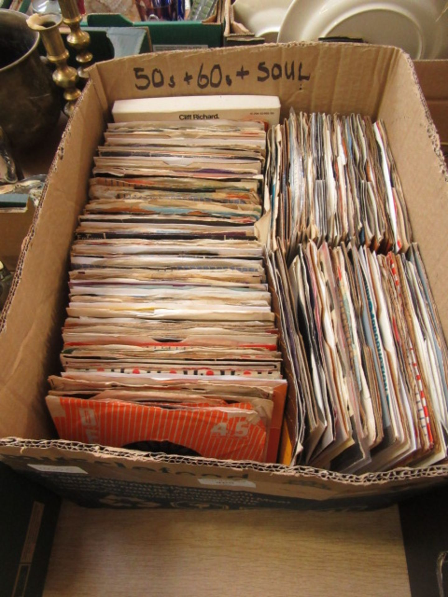 A box containing an assortment of 45 RPM singles by various artists