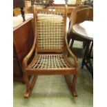 An early 20th century mahogany rocking chair with a leather slatted seat and back